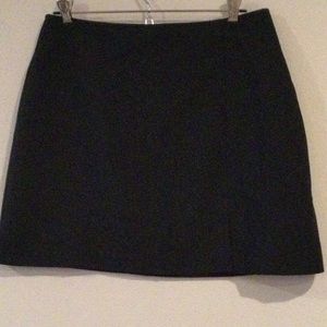 Black miniskirt with slit in front & a zipper in the back.